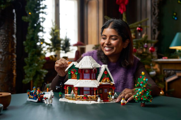Een bouwer met LEGO Icons Oma’s kersthuis 11387 in een kerstinterieur